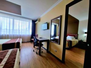 康塞普西翁埃尔阿拉乌卡诺酒店的酒店客房设有两张床、一张桌子和一面镜子