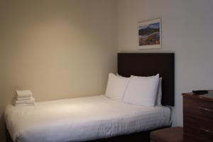 伦敦大广场服务公寓的酒店客房,配有白色床单