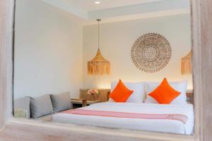 查汶LOVE beach club Koh Samui的一间卧室配有一张带橙色枕头的大床