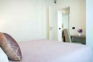 阿尔盖罗Milena Suite Apartments的一间卧室配有一张床和一张桌子及椅子