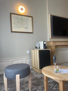 瑟堡Hotel Le Cercle的客厅配有蓝色凳子和电视