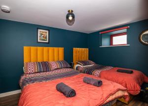 RáistínBartholomew's Loft的蓝色墙壁客房的两张床