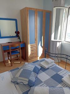 阿齐亚·佩拉加·基西拉Απεραντο Γαλαζιο的一间卧室配有一张床、一张桌子和一张书桌