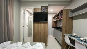 库里提巴09- Studio lindamente decorado! Ideal para casal!!!的小房间配有电视和桌椅