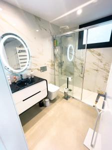 吉马良斯Casa Tranquilidade - Casa moderna com piscina的带淋浴、盥洗盆和镜子的浴室