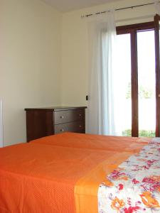 FilandariBorgo Nicoletta Case per le vacanze的一间卧室配有一张床、一个梳妆台和一扇窗户。