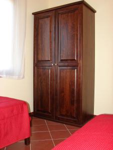 FilandariBorgo Nicoletta Case per le vacanze的红色床的房间里木柜