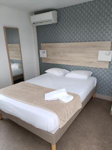 热尔扎克莱蒙费朗哲泽法斯特酒店的卧室里一张带两条毛巾的床
