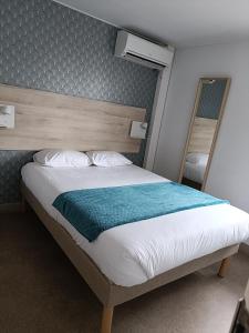 热尔扎克莱蒙费朗哲泽法斯特酒店的一间卧室配有一张带木制床头板的床