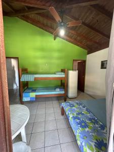加罗帕巴Pousada Via Ferrugem的客房设有两张双层床和一台冰箱。