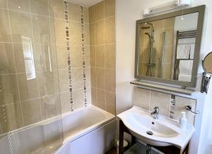 凯西克雷文斯通旅舍乡间酒店的一间带水槽、浴缸和镜子的浴室