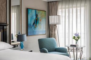 开罗开罗城市之星洲际酒店 的酒店客房,配有一张床和一张蓝色椅子