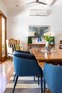 汤斯维尔Denham Heights的一间带木桌和蓝色椅子的用餐室