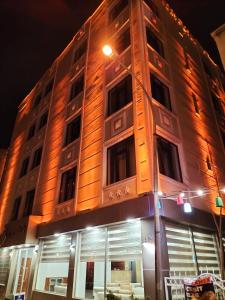 科尼亚Pirotel Hotel的夜晚高大的建筑,有街灯