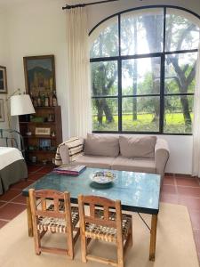 圣洛伦索La Justina - Casa de Campo en San Lorenzo的客厅配有沙发、桌子和两把椅子