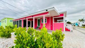 萨拉索塔Flamingo Tiny Home的街道边的粉红色绿色房子
