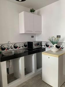 皮斯科Apartamento en Pisco的厨房配有黑色柜台和白色橱柜