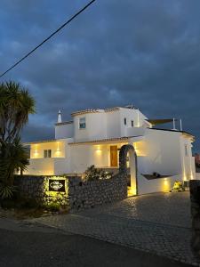 卢斯Casa Malìa Luxury Guest House的前面有石墙的白色房子