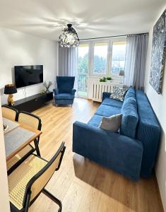 文盖尔斯卡－古尔卡Apartament 55的客厅配有蓝色的沙发和桌子