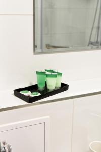 文盖尔斯卡－古尔卡Apartament 55的浴室柜台上备有三杯绿茶的托盘