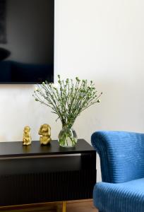 文盖尔斯卡－古尔卡Apartament 55的蓝色沙发旁边的桌子上花瓶