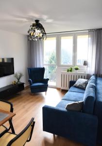文盖尔斯卡－古尔卡Apartament 55的客厅配有蓝色的沙发和椅子