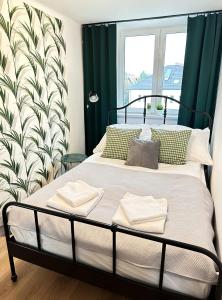 文盖尔斯卡－古尔卡Apartament 55的一间卧室配有一张带绿色窗帘的床和窗户。