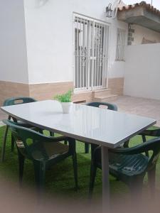 赫雷斯-德拉弗龙特拉Casa en Jerez con patio cerca de la playa y de la sierra的院子里的白色桌子和椅子