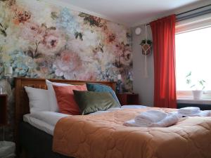 赖特维克Lustigsgården Boutique Hotel的一间卧室设有一张带花卉墙壁的大床
