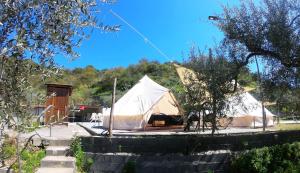 莫塔卡玛斯特拉Gole Alcantara mini Campeggio privato的一座带建筑物的田野上的大型帐篷