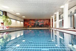 希洛谢克瓦利赛运动酒店的大楼内一个蓝色瓷砖的大型游泳池