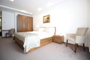 萨拉热窝Hotel R的一间卧室配有一张大床和一把椅子