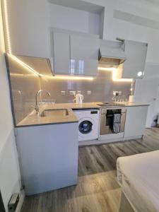 伦敦Baker Street Suites的厨房配有白色橱柜和水槽
