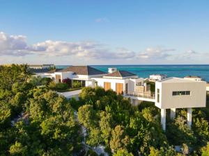 普罗维登西亚莱斯岛Breathtaking Oceanfront Villa with Views and Private Pool的背景中海洋的房屋的空中景观