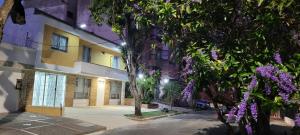 布卡拉曼加Casa 59 - Guest House的一座在前面布满紫色花的建筑