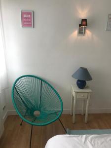 乌瑞基尼vacances的一张蓝色椅子,放在一个配有灯和桌子的房间