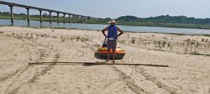 AuraiyaPachnad Camping And Water Sports Adventure的木筏站在海滩上的人