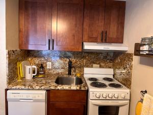 西优胜美地Yosemite Condominium Loft unit -B202的厨房配有水槽、炉灶和橱柜。