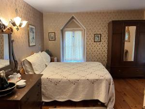 里穆斯基Manoir Guay Lafontaine的一间卧室配有一张床、梳妆台和镜子