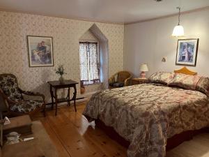 里穆斯基Manoir Guay Lafontaine的卧室配有床、椅子和窗户。