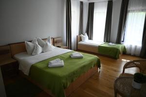 UzlinaEgreta By Hoxton的酒店客房,配有两张带绿床单的床