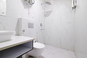 新德里Hotel Qubic Stay Near Delhi Airport的白色的浴室设有卫生间和淋浴。