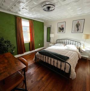 奥古斯塔Augi's Den. Close to Masters. Modern. Fun的一间卧室配有一张带绿色墙壁和木地板的床。