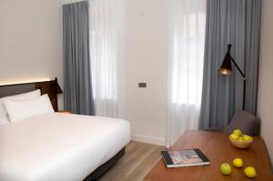 萨拉曼卡Prisma Suites的酒店客房设有一张床和一张桌子
