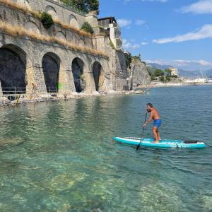 维耶特里B&B DieMme Amalfi Coast的站在水中桨板上的人
