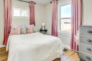 沃特敦Pet-Friendly Watertown Home about 1 Mi to Downtown!的一间卧室配有一张带粉红色窗帘的床和窗户。