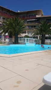 布科·莱斯白老城Le Boucanier的一座大型游泳池,在一座建筑前种有棕榈树