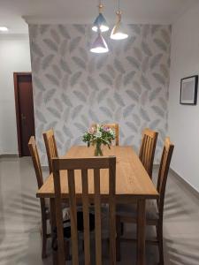 亚的斯亚贝巴Casa Feliz - Stylish 2 Bedroom Apartment的一间带木桌和椅子的用餐室