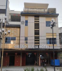 KisaranGrand Mulia Hotel Kisaran的前面有标志的建筑