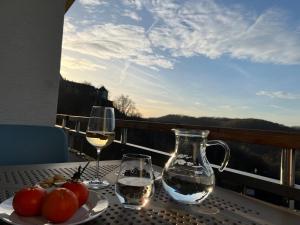 瓦尔德克Fi-Suiten的阳台上的桌子和两杯葡萄酒